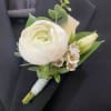 Exude royalty and regality in this beautiful white ranunculus boutonniere, greenery and
