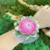 Corsage with a pink ranunculus at the center. 
