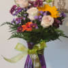 &quot;A bright and cheerful mix of sunflowers, roses, daisies, and snapdragons, arranged