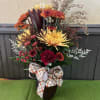 A mixture of Fall flowers beautifully arranged in a Fall colored vase