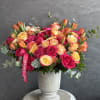 A radiant mix of pink, yellow, and orange roses and tulips &mdash;