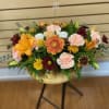 Fall centerpiece with mixed flowers and candles. The arrangement contains orange lilies