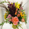 Safari Leucadendron, peach ranunculus, roses, lilies, snapdragons,  sunflowers, solidago, and ornamental