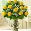 One dozen yellow roses arranged in a vase. Due to availability, the