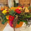 A great fresh pumpkin with fall assorted flowers spilling out to create