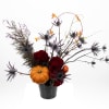 A moody autumnal arrangement featuring mini pumpkins, spiky spider thistle, rich garden