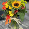 Sunflowers and other fall colors arranged in a mason jar
