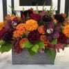 Vibrant Fall assortment with oranges and burgundy&#039;s in a wood box to
