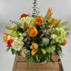 A Stunning Floral Arrangement with orange ranunculus, orange Lilies, green mini Hydrangea