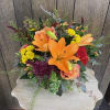Textural mix of roses, cherry brandy roses, celosia, mums, seeded eucalyptus, lilies