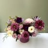 A lush fall arrangement brimming with dahlias, anemones, and soft garden blooms