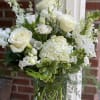 All white, beautiful arrangement with seasonal blooms and interesting greens. Perfect for