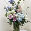A tall pastel, beautifully designed arrangement of seasonal blooms and a great