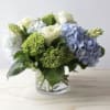blue &amp; green hydrangea, white roses and greens in a glass cylinder