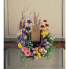 This beautiful wreath with its eternally vibrant spring flowers respectfully adorns a