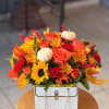Bursting with rich autumn colors, this white purse overflows with sunflowers, roses