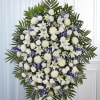A beautiful standing spray which includes white lilies, blue delphinium, white roses