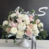 A sophisticated arrangement of white peonies and roses, showcasing the elegant blend