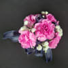 Beautiful mini carnations on a bed of greens with matching ribbon. Available