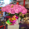 We design 3 dozen purple roses in a vase with extra fillers