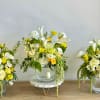 A fresh arrangement of white and yellow flowers arranged in a clear