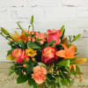 Vibrant shades of orange flowers in a glass cube. A fun feel