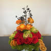 red roses mixed with bright orange ranunculus with a hint of citrus