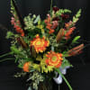 Bright flower bouquet full of fall flowers. Orange gerber daisies, lily buds