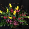 Bowl full of tulips and filler flower plus whimsical willow branches. Colors