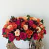A vivid combination of roses, orchids, and spray roses in lively shades