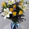 A vase arrangement with a delightful mix of blooms. Yellow Roses, White