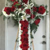 This elegant funeral cross features a striking row of red roses cascading