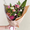 A delicate wrapped bouquet designed with a fresh mix of roses, lisianthus