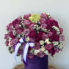 A vibrant mix of lavender roses, orchids, spray roses, and white accents