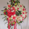 Standing circular spray in tones of white and red with roses, gerber