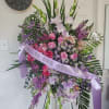 Standing funeral spray with beautiful tones of pink, lavender, and white gladiolus