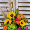 Our beautiful white ceramic pumpkin filled with sunflowers, orange spray roses, a