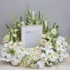 This urn tribute wreath includes a mix of orchids, roses, and seasonal