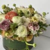 This lush composition is surrounded by a mixed of premium ranunculos like