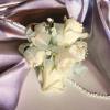 Our florists hand-craft a gorgeous white rose corsage accented with fresh greens