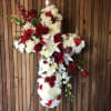 A beautiful blend of white and red flowers on a cross