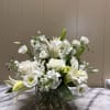 All white fresh arrangement in a short glass cube vase , flowers