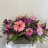 Berry colored assorted flowers arranged in a wooden box.