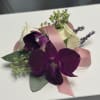 Exotic and sophisticated, this corsage features vibrant purple orchids accented with delicate