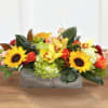 A beautiful traditional fall centerpiece of mixed autumn colors, showcasing festive sunflowers.