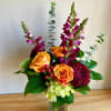 This elegant vase is filled with a beautiful arrangement of purple and