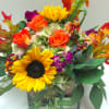 A beautiful fall assortment of fresh blooms including roses, sunflowers, green hydrangea