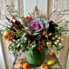 Enjoy this seasonal arrangement of black roses, kale and autumnal accents.