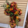 Mixed fall cut flowers - red roses, orange carnations, brown cushions, gold