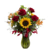 This glistening green glass vase is home to Sunflower, red Roses, preserved